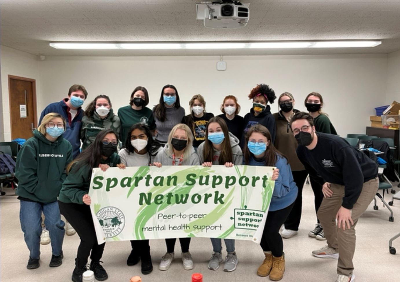 Photo of SSN in a classroom holding an SSN banner